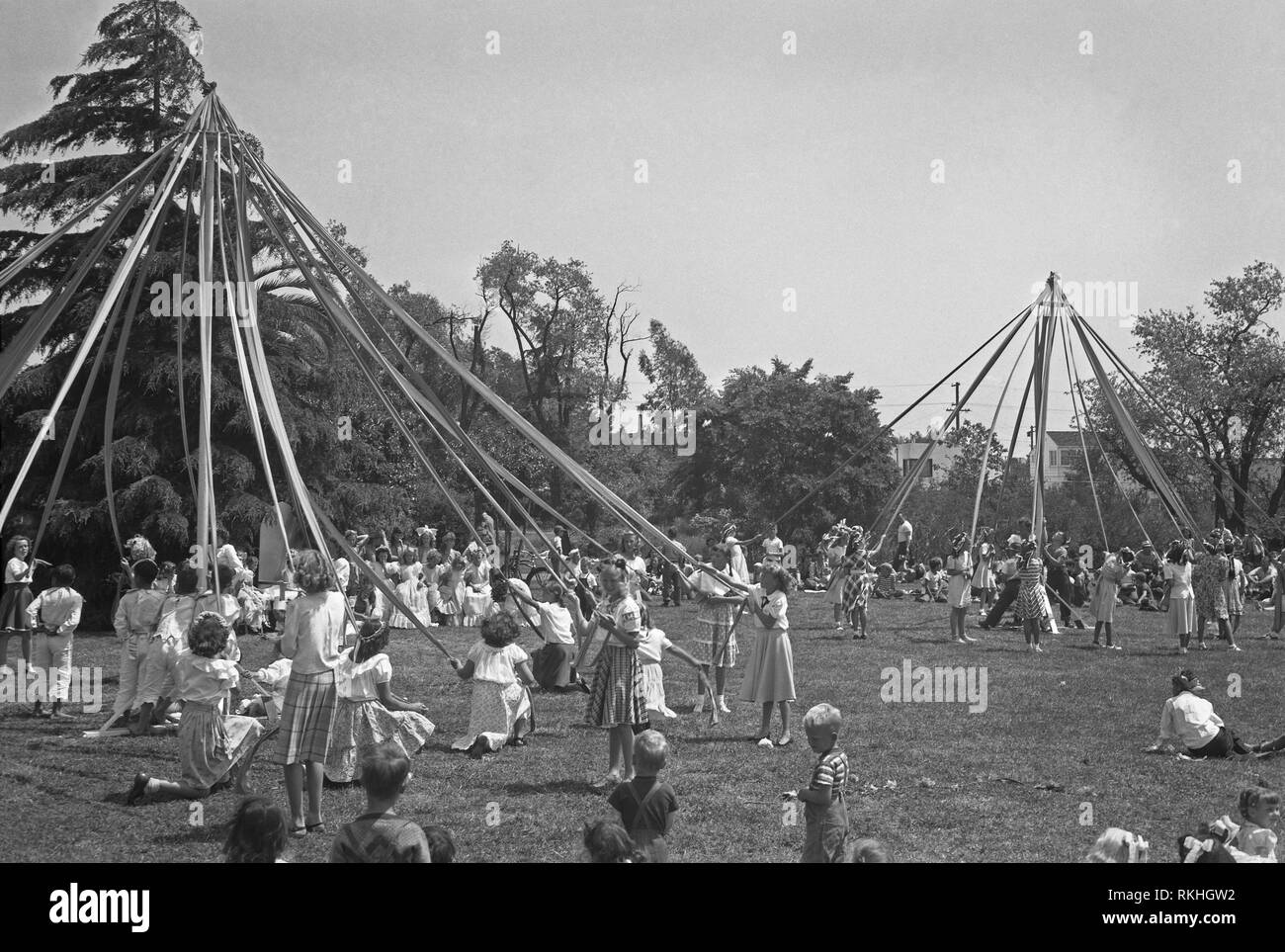 Due Maypoles con i bambini danza intorno a loro sulla Mayday, STATI UNITI D'AMERICA c.1960 Foto Stock