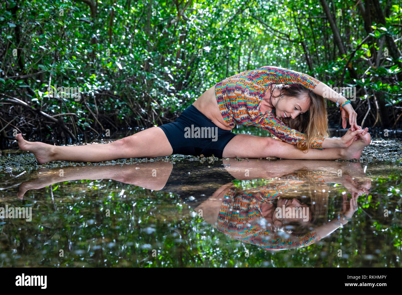 Giovane donna a praticare yoga (trampolo Split) in un ambiente naturale - Fort Lauderdale, Florida, Stati Uniti d'America Foto Stock