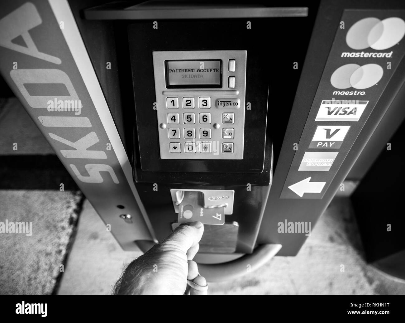 BASEL, Svizzera - Mar 22, 2018: il punto di vista della mano maschio prendendo un Transferwise carta di credito fuori da un parcheggio teller machine dopo il pagamento è accettato - in bianco e nero Foto Stock