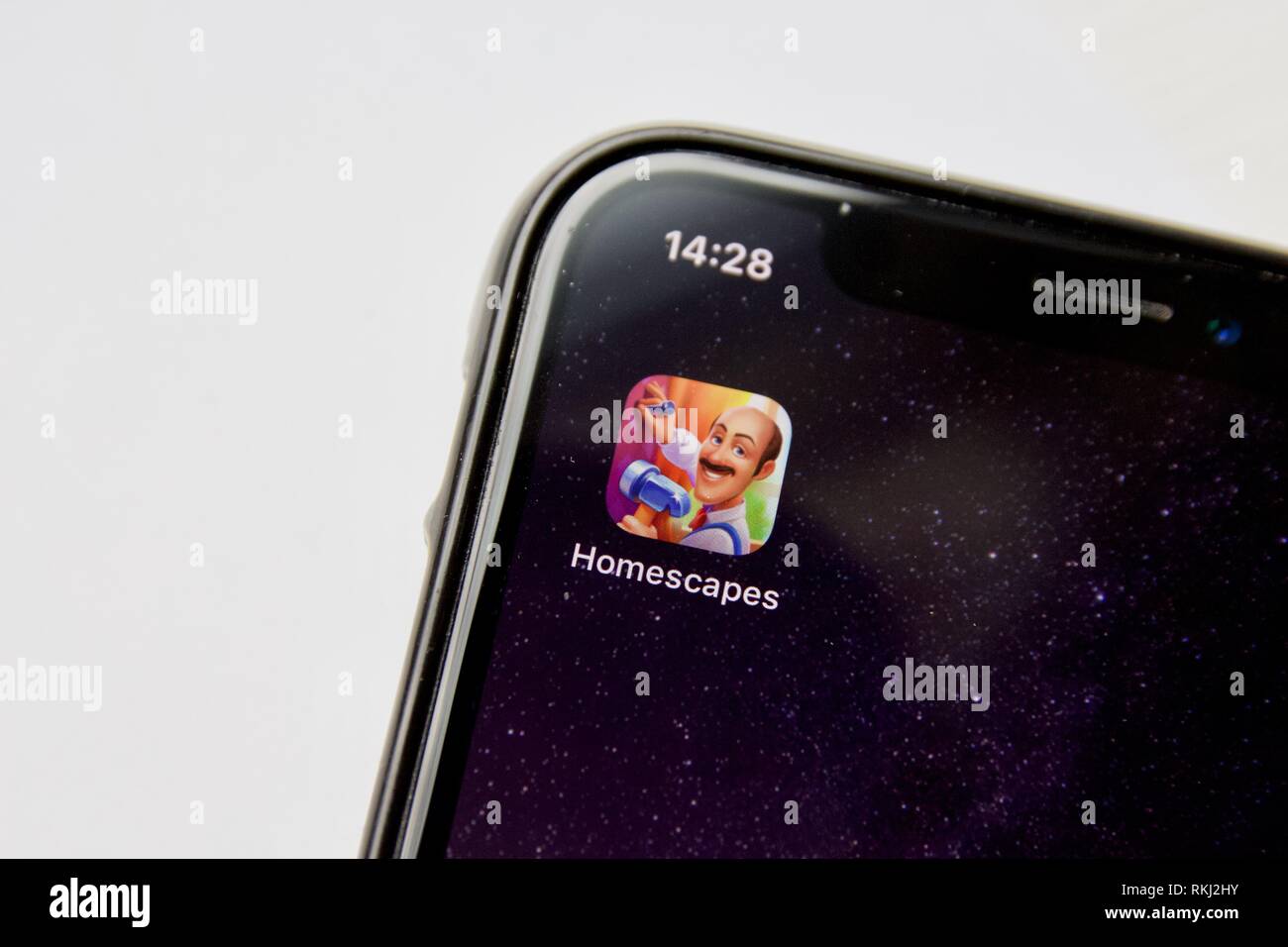 Homescapes da Playrix su un iPhone X contro uno sfondo bianco. Homescapes è una corrispondenza 3 plus resource management gioco, uno spin-off da Gardenscapes. Foto Stock