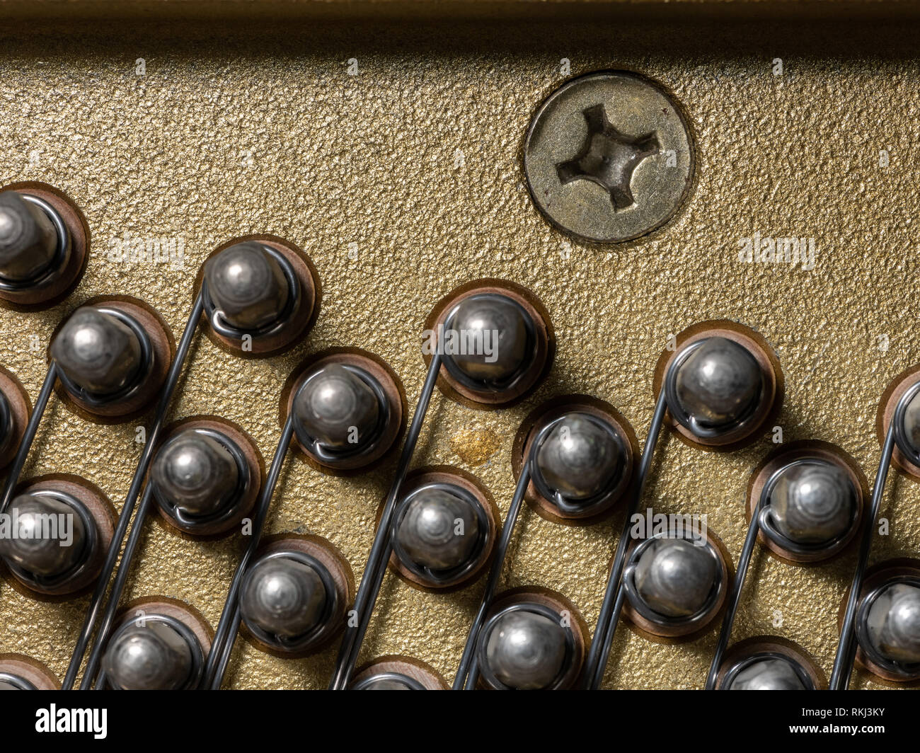 Abstract closeup dell'interno di un pianoforte verticale, perni di sintonizzazione Foto Stock