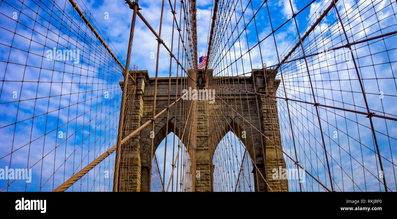 Ponte di Brooklyn struttura del cavo con nuvoloso cielo blu Foto Stock