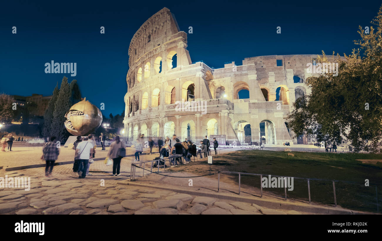 Colosseo romano e i turisti di notte a Roma, Italia, persone sfocato Foto Stock