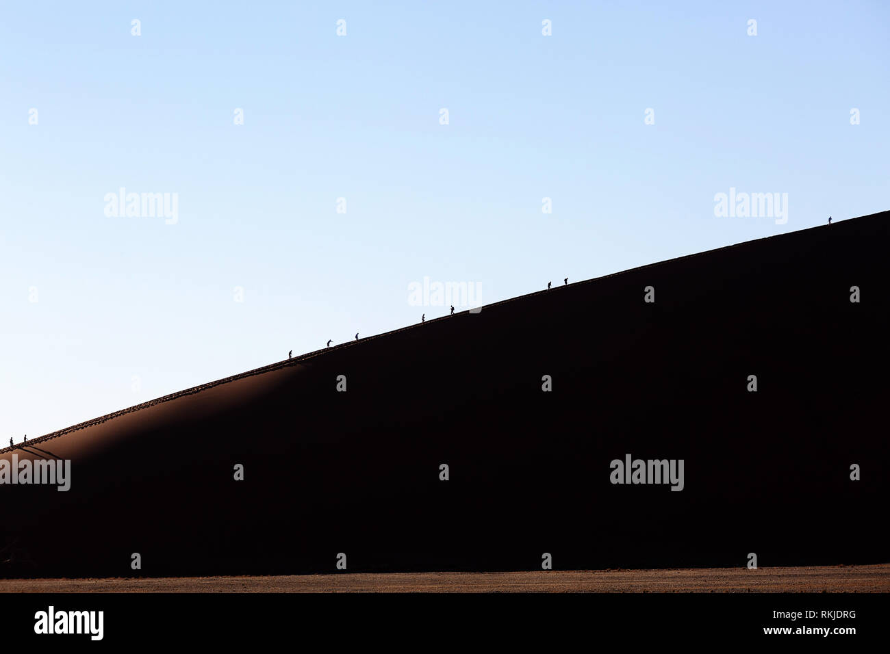 I turisti la scalata al Sossusvlei dune in Namibia Foto Stock