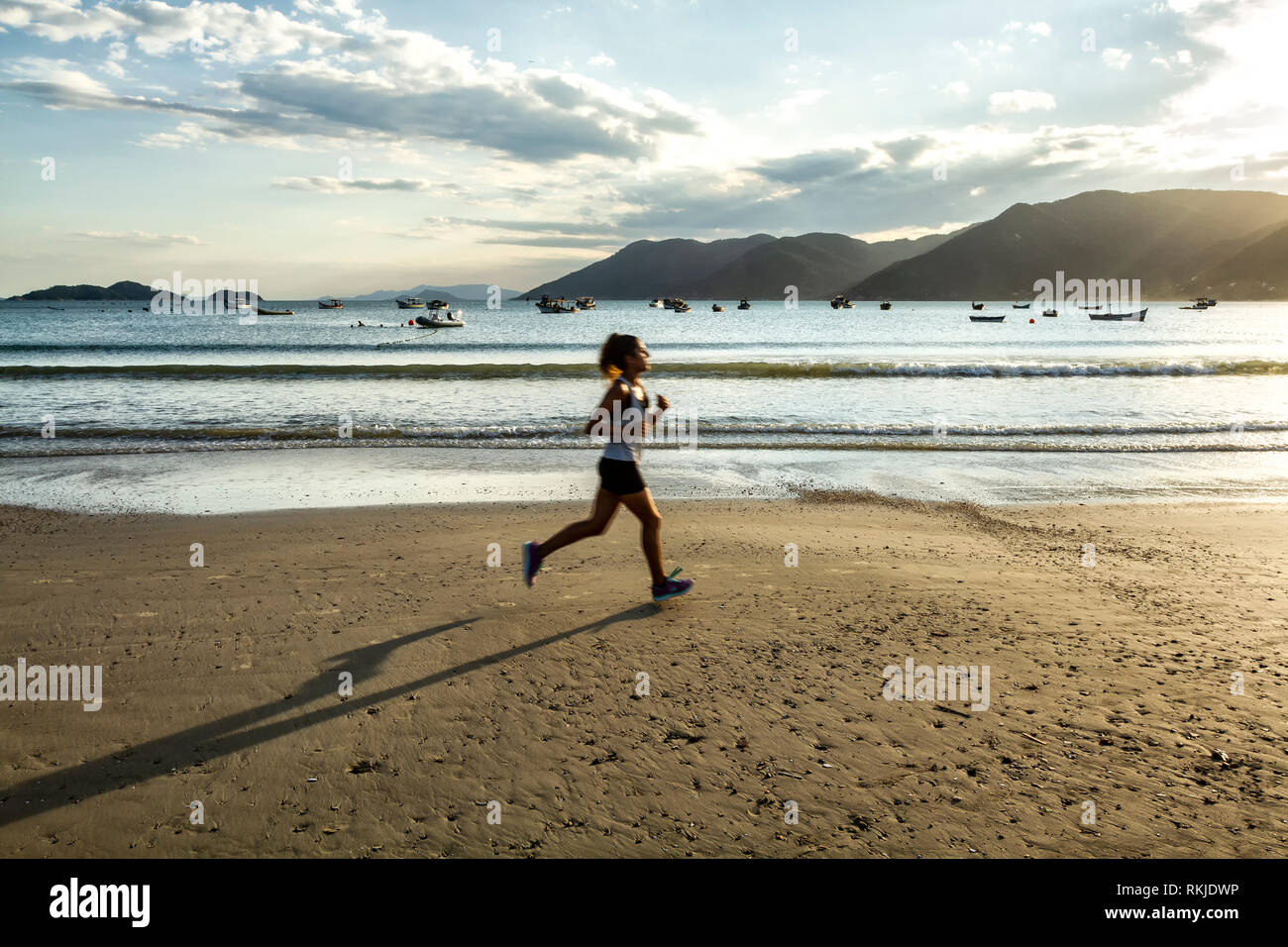 La donna in esecuzione a Pantano do Sul Mare. Florianopolis, Santa Catarina, Brasile. Foto Stock
