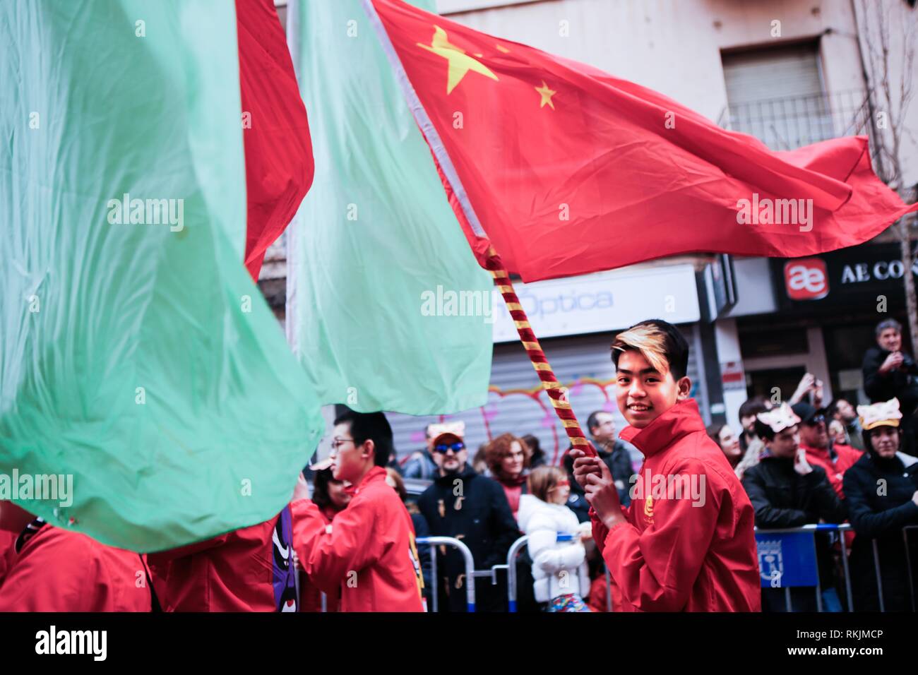 Madrid, Madrid, Spagna. 10 Febbraio, 2019. Un uomo con i capelli colorati sfila per le strade tenendo una bandiera della Repubblica popolare di Cina durante le celebrazioni.Madrid celebra il Capodanno Cinese con una grande sfilata piena di musica e il colore predominante il colore rosso della sorte e la fortuna con enormi leoni e draghi e il suo protagonista principale è il maiale. L Utentea quartiere di Madrid è riempito con migliaia e migliaia di persone che frequentano il festival con la partecipazione di più di mille e duecento artisti tra le diverse associazioni culturali relativi al pe Foto Stock