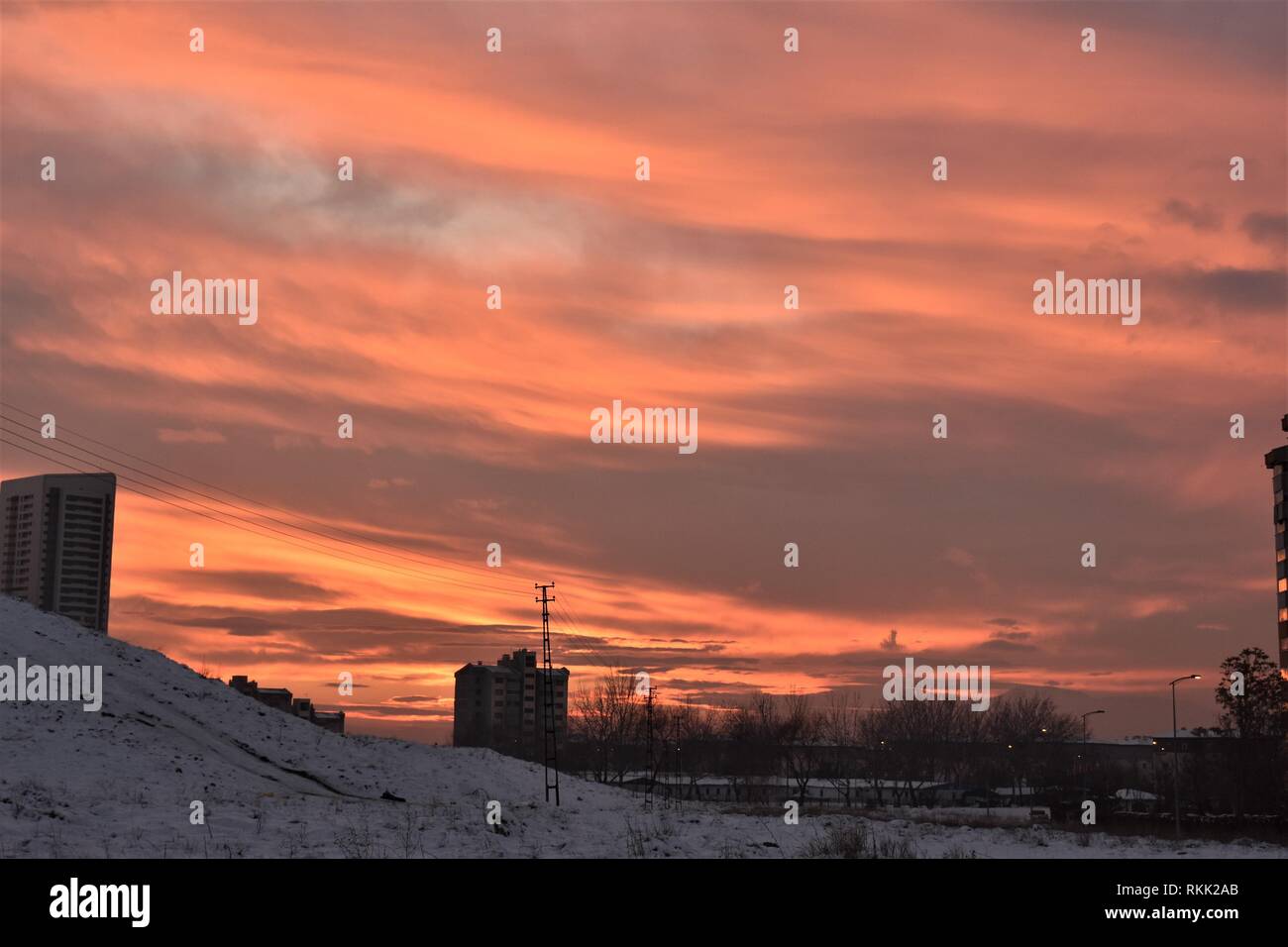 Ankara, Turchia. Decimo gen, 2019. Copertura nuvolosa un rosso sangue cielo sopra gli alberi e gli edifici residenziali durante il tramonto in un sobborgo occidentale. Credito: Altan Gocher | in tutto il mondo di utilizzo/dpa/Alamy Live News Foto Stock