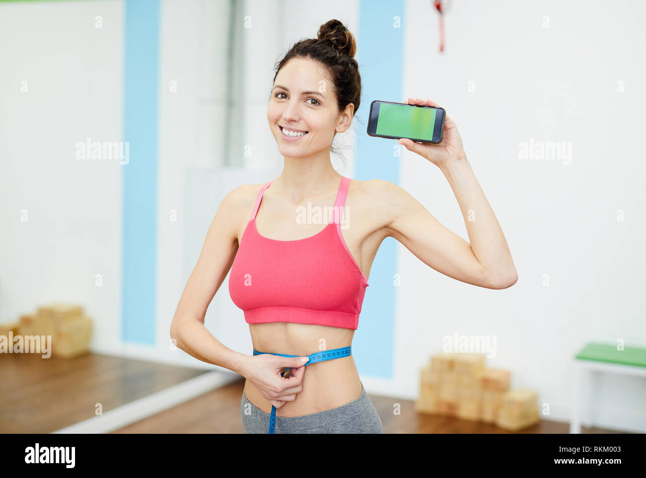 Donna sorridente presentando Weightloss App Foto Stock