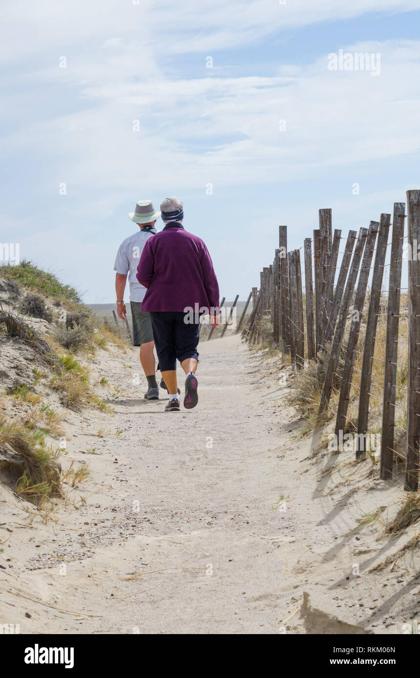 Coppia matura godendo di uno stile di vita attivo prendere scenic passeggiata costiera di godere il telecomando il paesaggio costiero, la Penisola Valdes, Argentina. Foto Stock