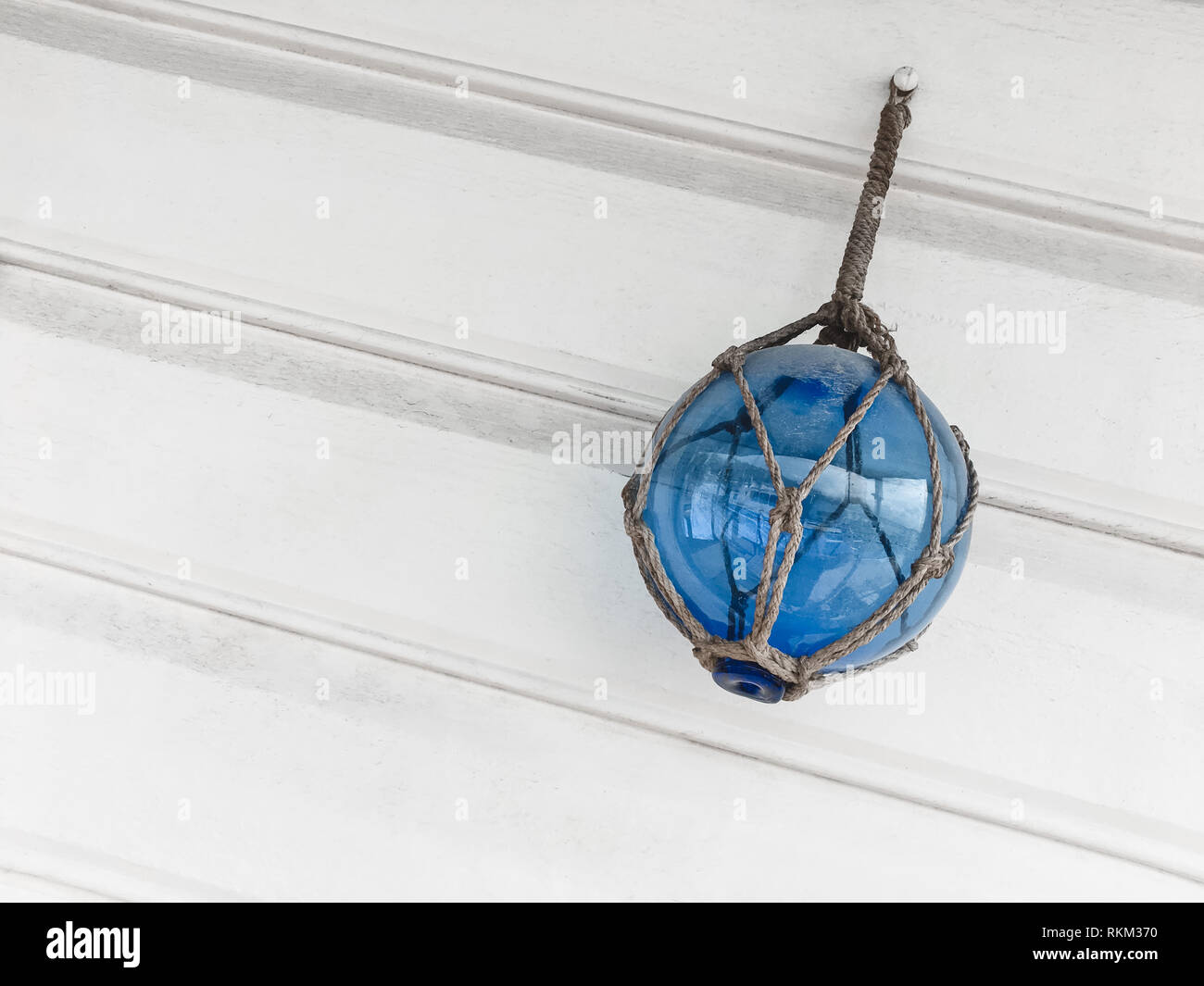 Blue Palla di vetro decorare un bianco parete in legno. Mare decor di stile. Foto Stock