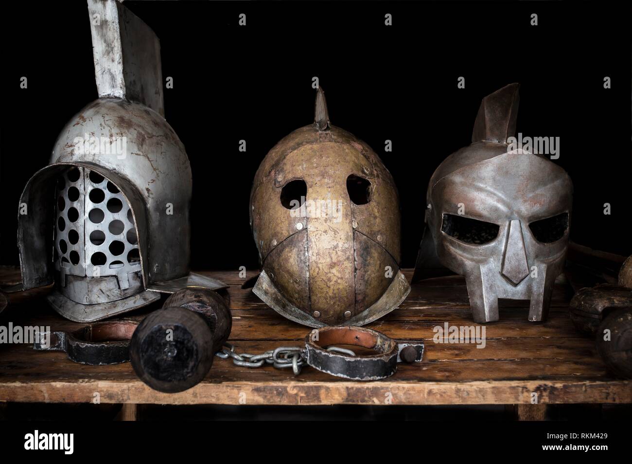 Gladiatori tabella con i caschi, spade e shakles. Antico romano di ricostruzione. Foto Stock