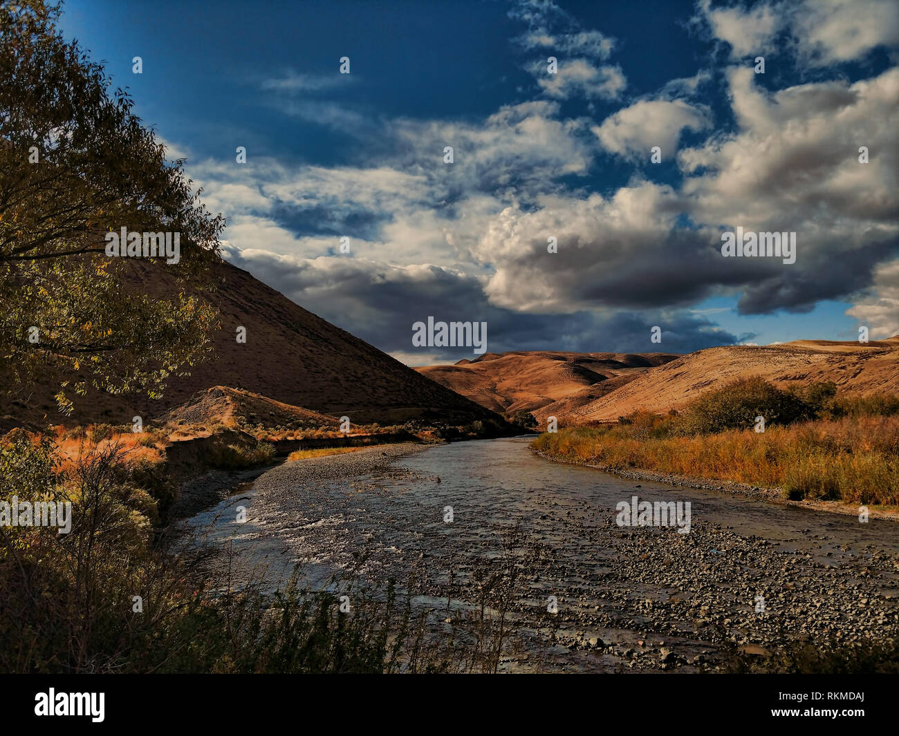 Un fiume fette attraverso brulle colline marrone in Oregon orientale in autunno. Foto Stock