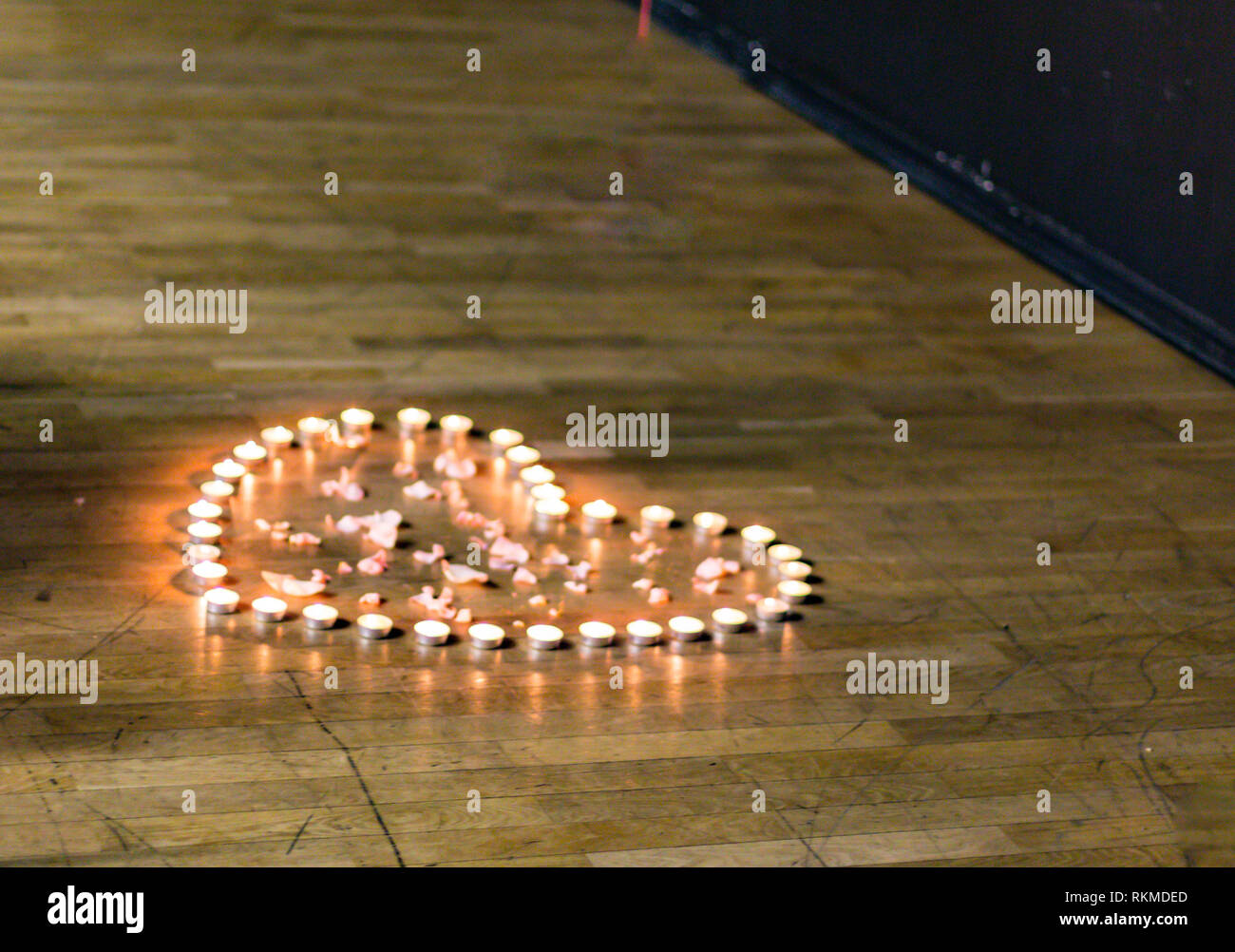 Silhouette di un cuore che è prevista con un piccolo tea candele sul palco Foto Stock
