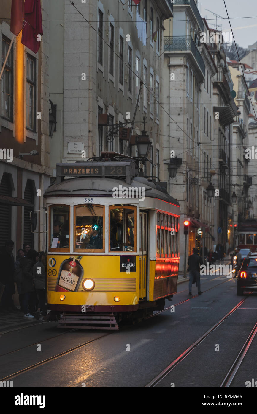 Lisbona, Portogallo - 12/26/18: Tradizionale giallo vecchio tram elettrico nel centro di Lisbona. Licor Beirao annuncio, Prazeres 28 tram Foto Stock