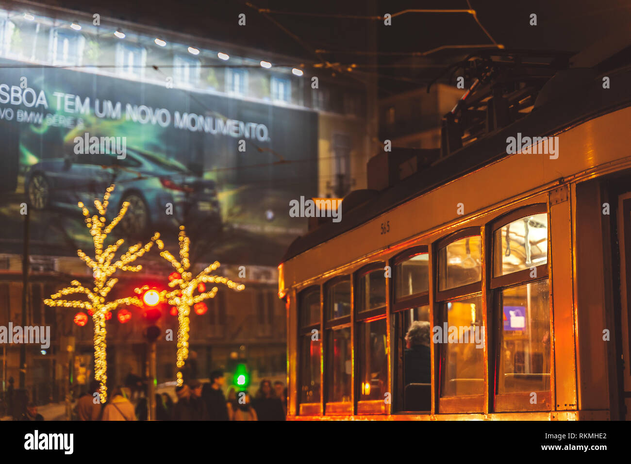Lisbona, Portogallo - 12/26/18: tram elettrico downtown Camoes Square, alto contrasto luminosi riflessi di luce da strada decorazioni di Natale di notte. Foto Stock