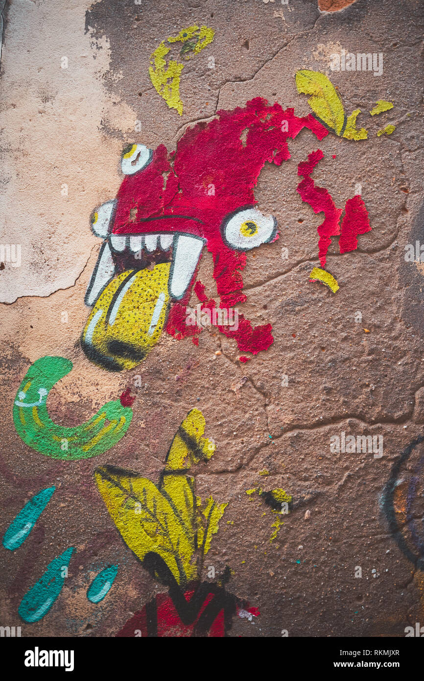 Lisbona, Portogallo - 01/03/19: Red Monster Graffiti nel centro cittadino di Bairro Alto, più gli occhi, la linguetta gialla e denti vampiro. Vernice che cade, essiccato fino wal Foto Stock