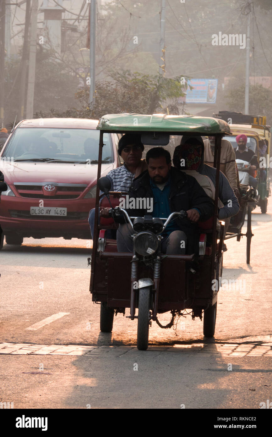 Uomo alla guida di auto elettriche rickshaw con passeggeri di Amritsar, India Foto Stock