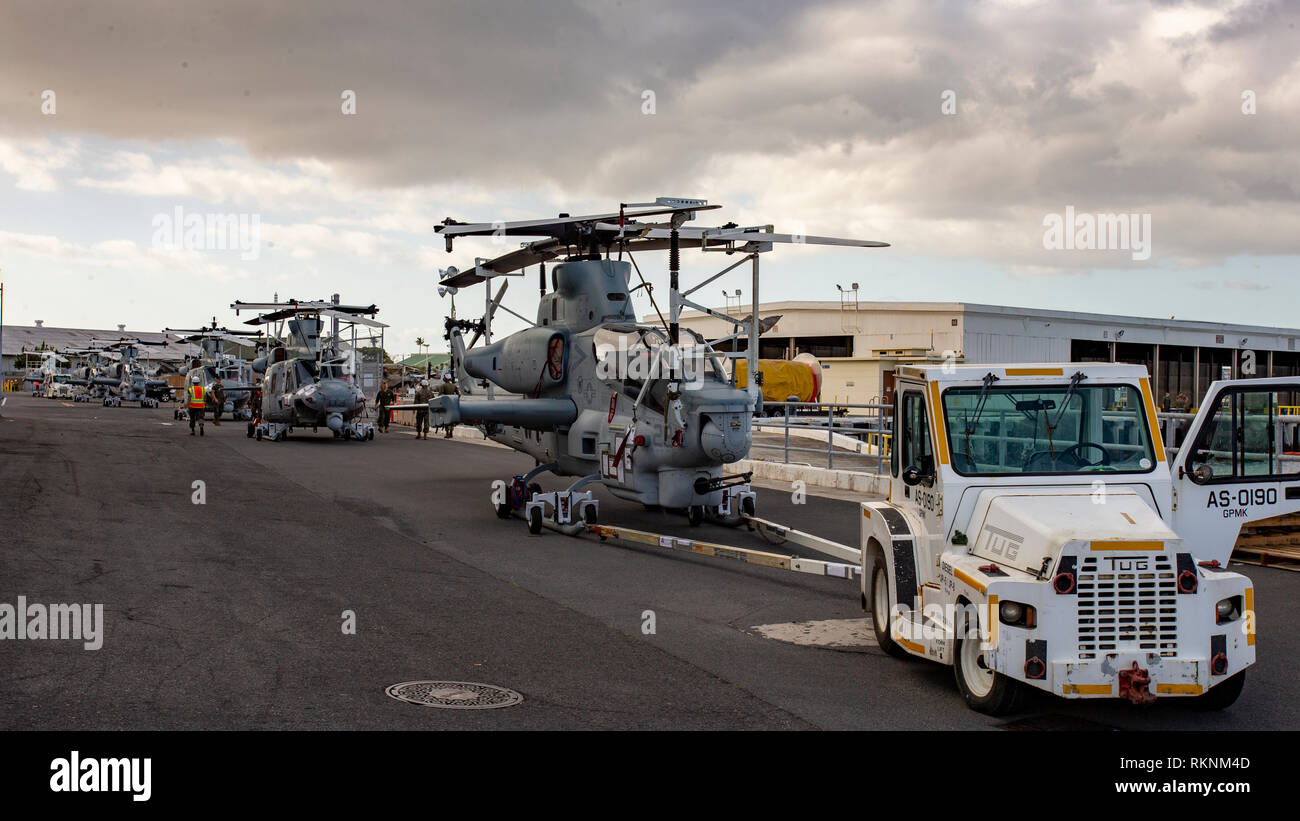 Stati Uniti Marines con Marine Attacco leggero elicottero Squadron 367 (HMLA-367) preparare per caricare i loro aerei su una nave a bordo di Pearl Harbor, Hawaii, 6 febbraio 2019. Il velivolo vengono caricati su una nave per essere trasportati per la loro prossima distribuzione. (U.S. Marine Corps foto di Sgt. Ricky Gomez) Foto Stock