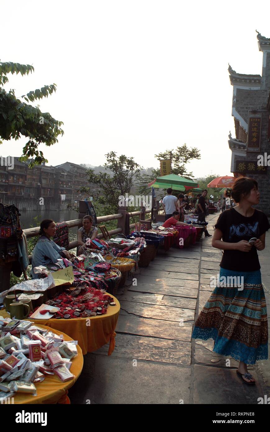 I venditori allestiscono un vivace e improvvisato mercato notturno lungo il fiume a Fenghuang, Hunan. Foto Stock