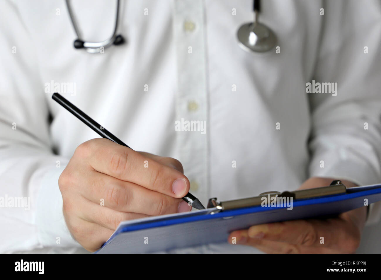 Medico con stetoscopio scrive una prescrizione carta, medical exam. Concetto di medicina, di diagnosi, di esame presso la clinica per la cura della salute Foto Stock