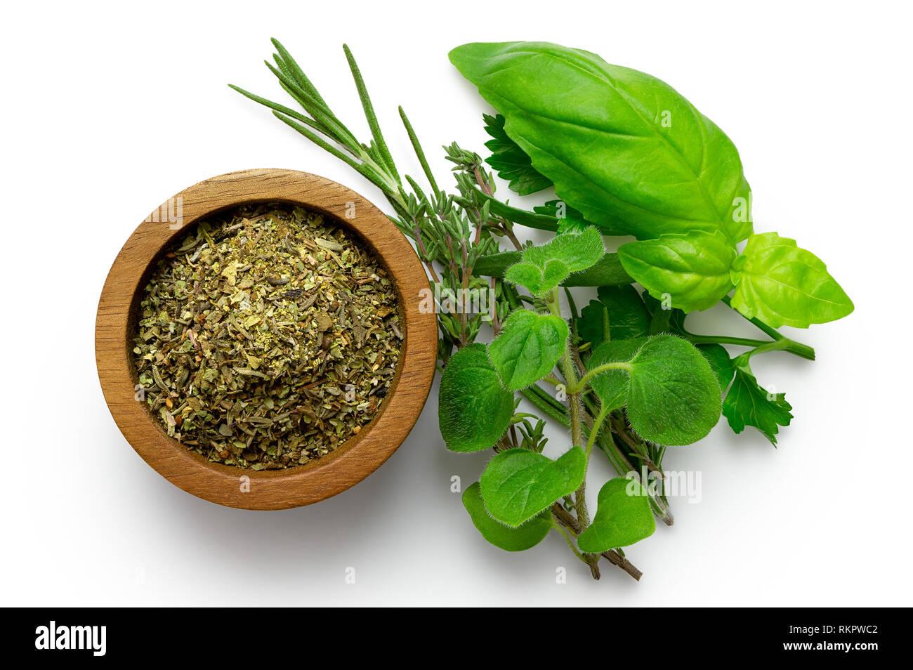 Essiccato trito di erbe di Provenza in un legno scuro ciotola accanto al bouquet fresco garni isolato su bianco dal di sopra. Foto Stock