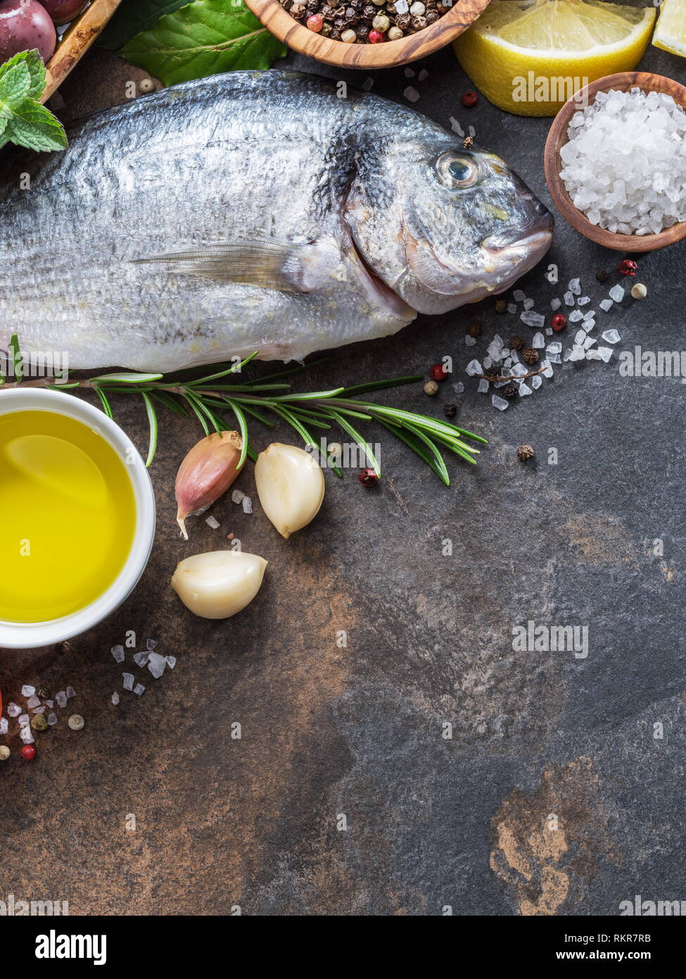 Materie dorado pesce con spezie e verdure sulla scheda di grafite. Vista dall'alto. Foto Stock