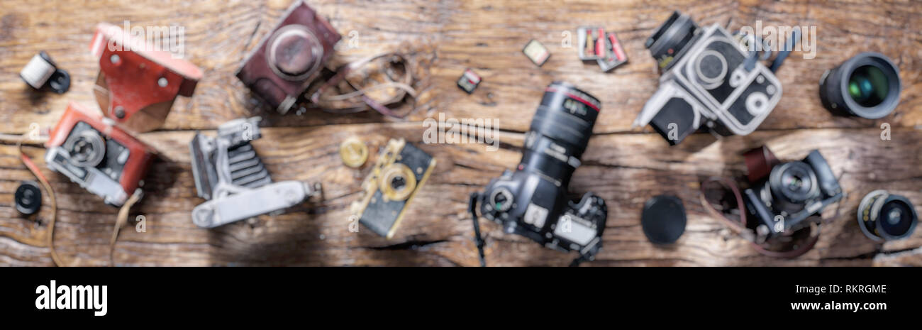 Sfocata foto panoramiche di diverse macchine fotografiche su sfondo di legno. Foto Stock