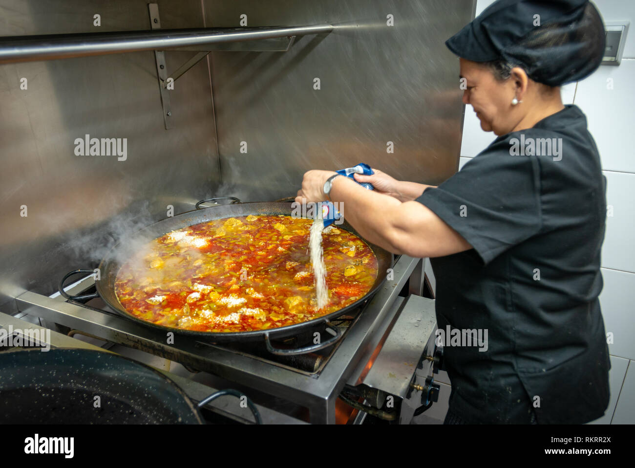 Una cucina dello chef paella in un ristorante di cucina a Valencia in Spagna. Foto Stock