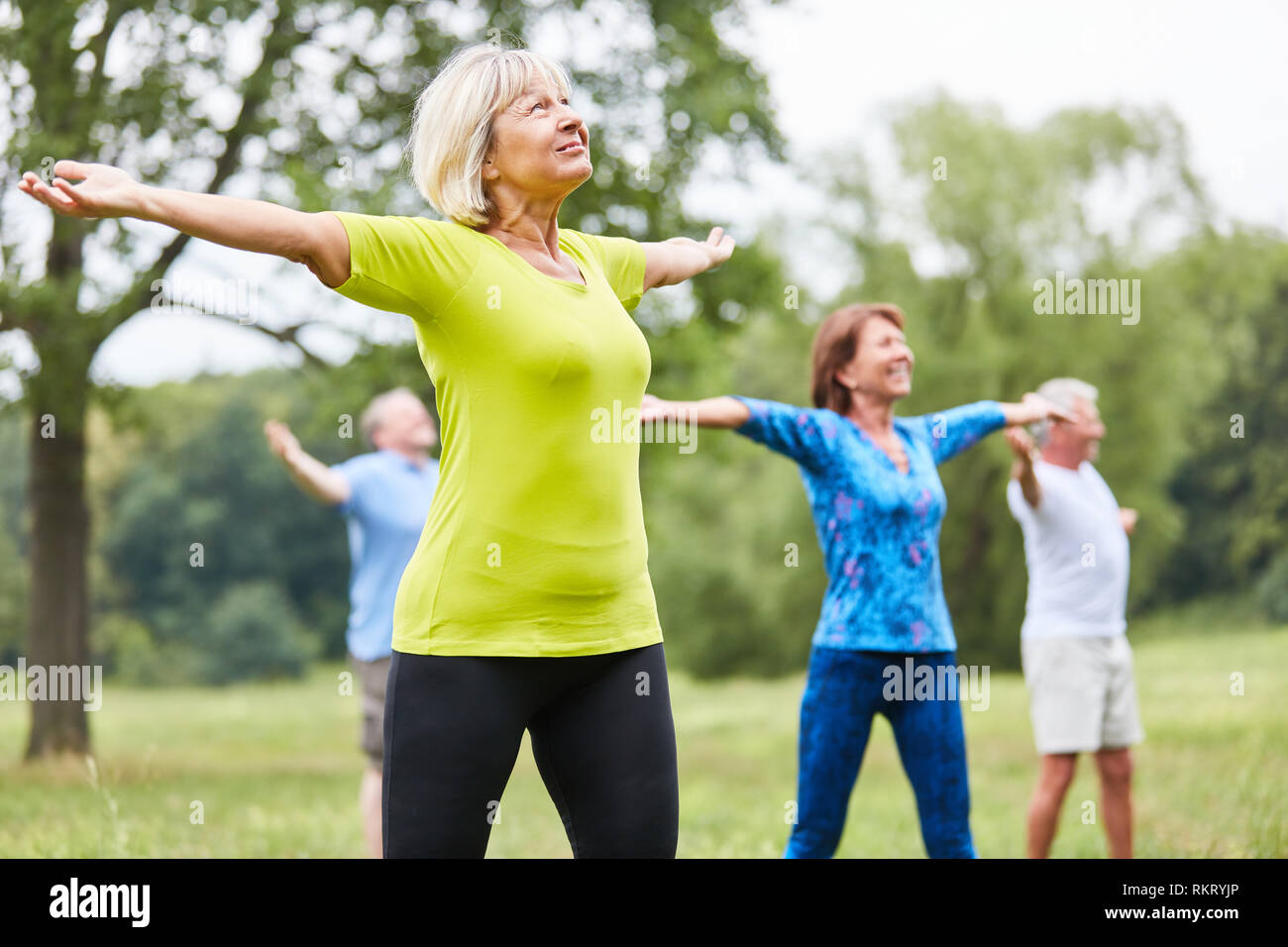 Di vitale importanza per gli anziani in un yoga o palestra classe con bracci stirata Foto Stock