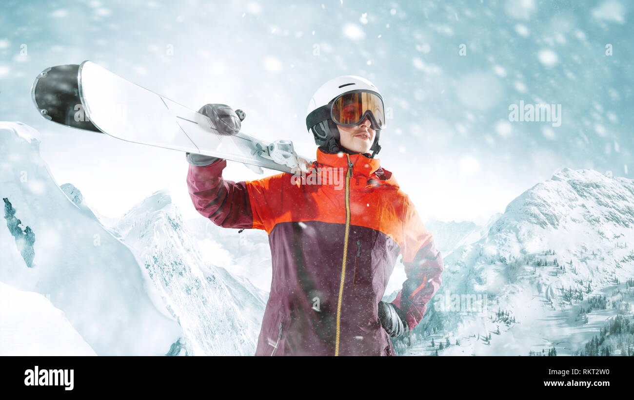 Sciatore femmina in piedi con cieli in una mano sullo splendido paesaggio delle montagne sullo sfondo. Inverno, sci, neve vacanze, sport, tempo libero, il concetto di stile di vita Foto Stock