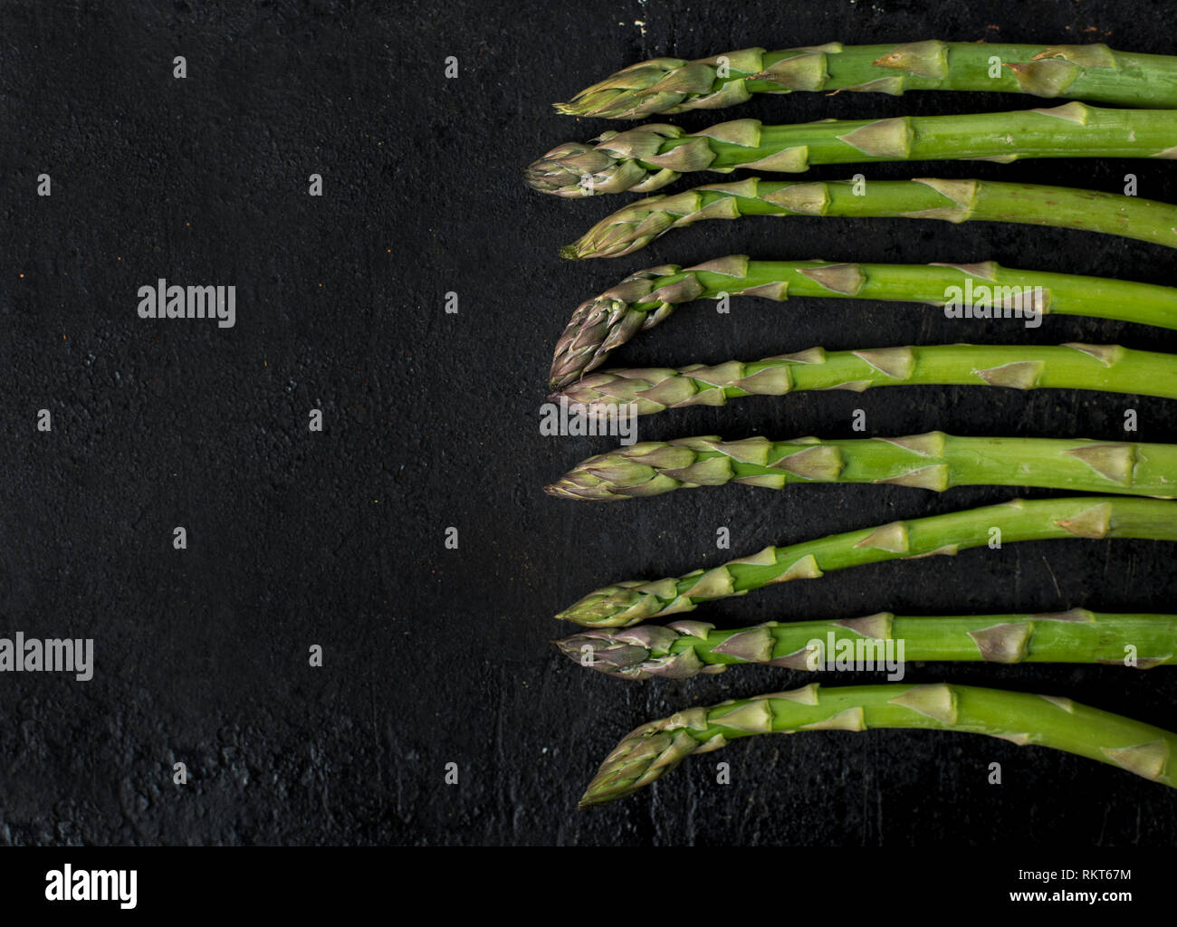 Vista dall'alto di freschi Asparagi verdi rustico lavagna nera con copyspace. Il cibo e la cucina ricetta dello sfondo. Foto Stock