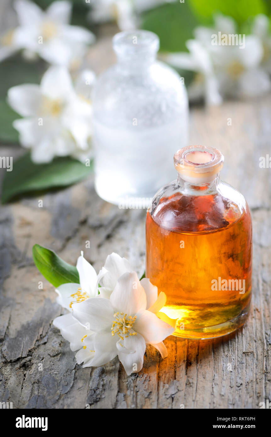 Olio essenziale di fiori di gelsomino. Massaggio Aromaterapico Olio su legno rustico sfondo. Foto Stock