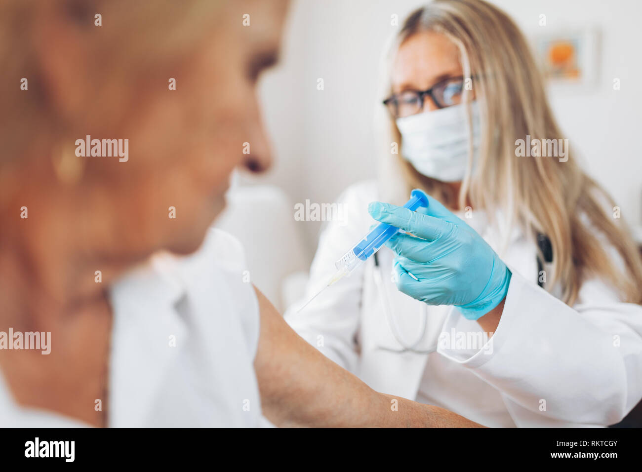 Medico la somministrazione di un vaccino su un paziente anziano Foto Stock