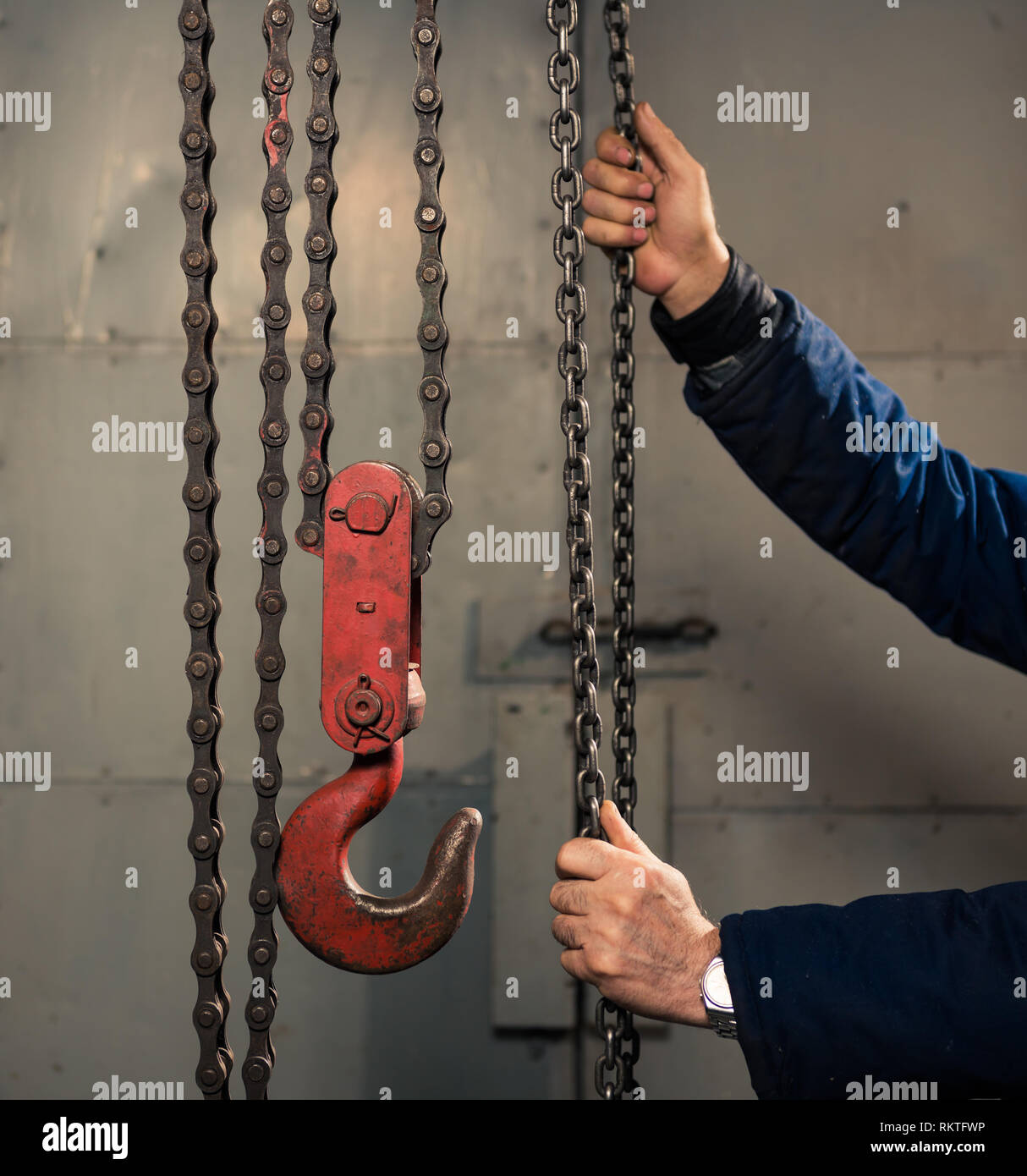 Senior uomo con catena metallica con red hook in sala tecnica Foto Stock