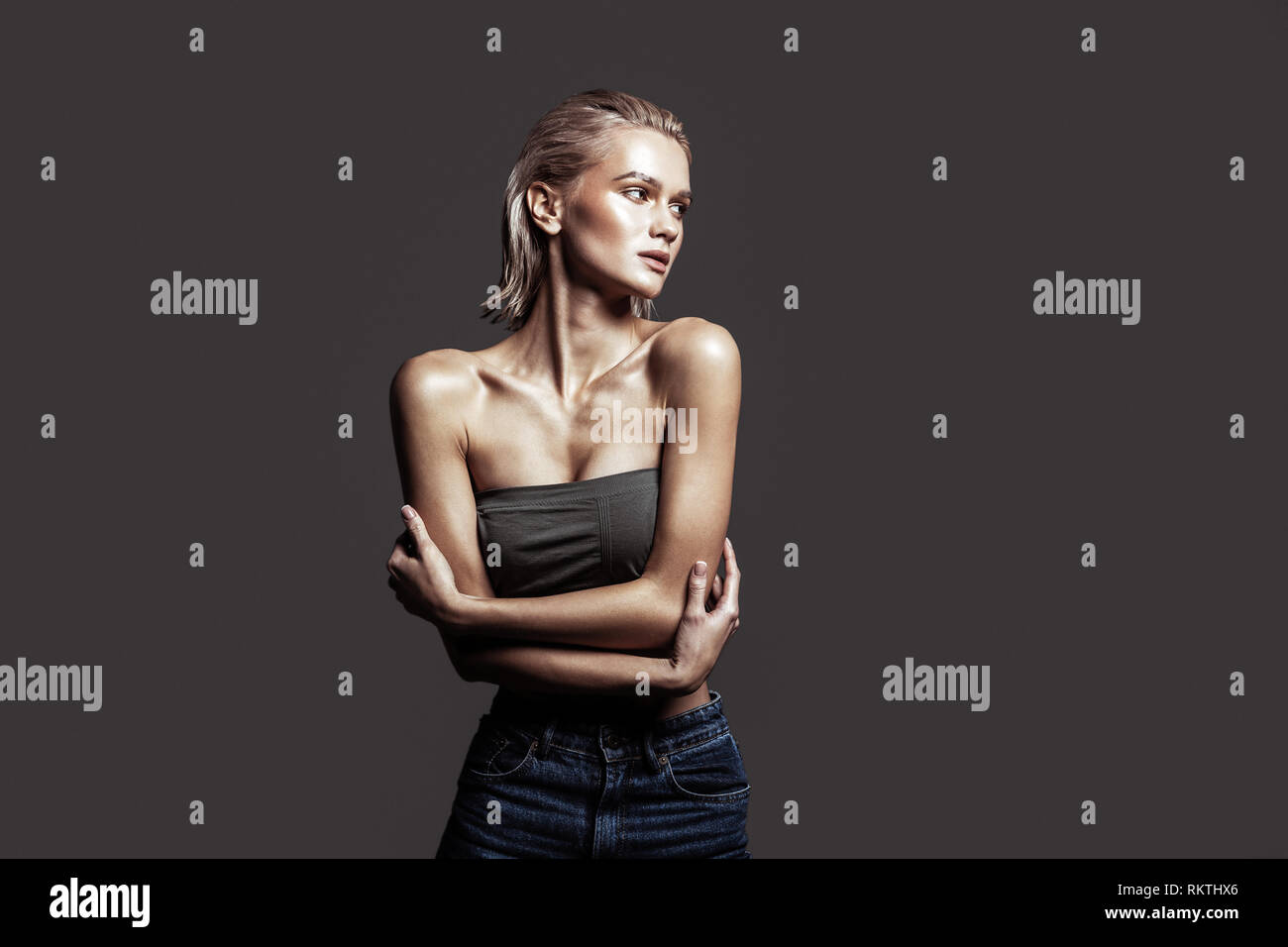 Slim donna che indossa jeans e breve top in posa professionalmente Foto Stock