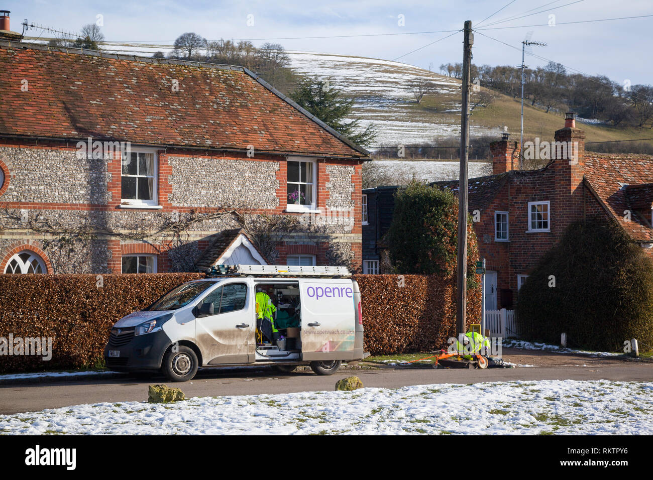 Un ingegnere BT OpenReach ripara una linea telefonica nel villaggio rurale coperto di neve di Turville, Buckinghamshire. Foto Stock