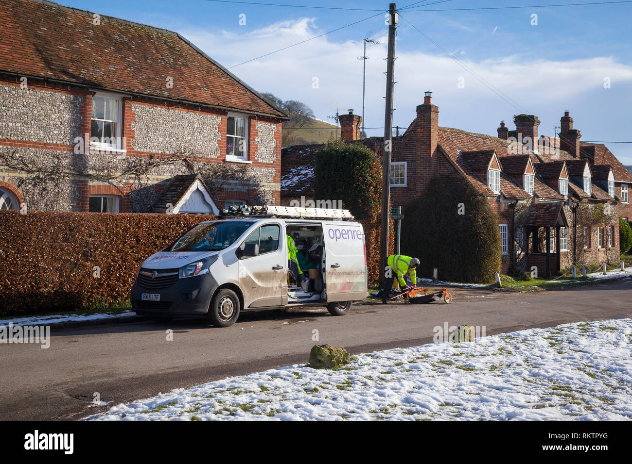 Un ingegnere BT OpenReach ripara una linea telefonica nel villaggio rurale coperto di neve di Turville, Buckinghamshire. Foto Stock