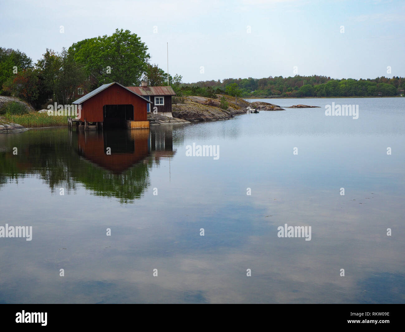 Il Boathouse riflessa nelle calme acque di un Mar Baltico canale vicino Mariehamn, Aland, Finlandia Foto Stock