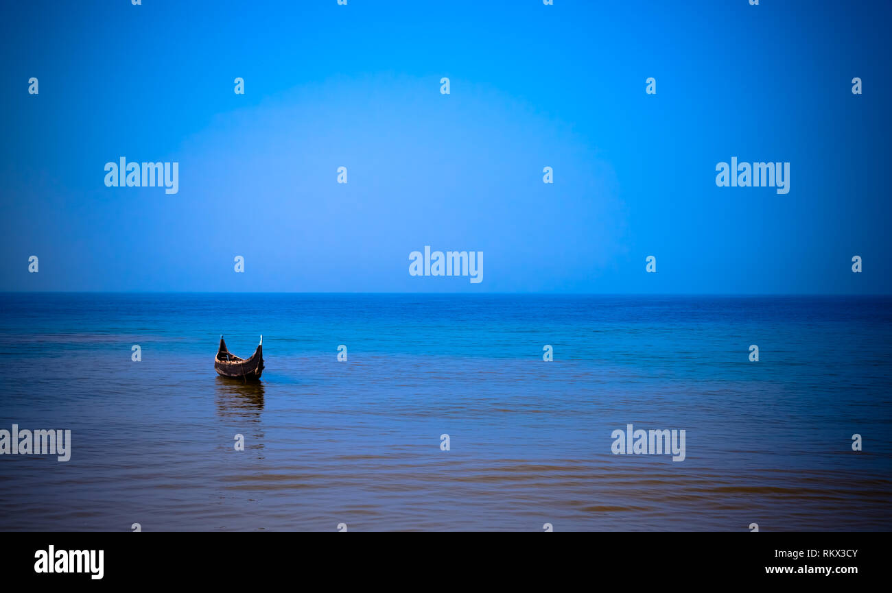 Lonely barca su un mare calmo - sfondo blu Foto Stock