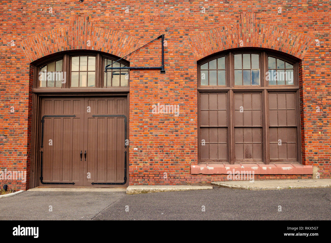 Una grande porta e finestra sul lato di un vecchio rosso edificio in mattoni Foto Stock