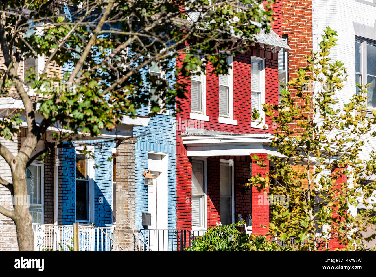 Riga di colorati di rosso e di blu di mattoni dipinto case residenziali case case architettura ingresso esterno a Washington DC Capitol Hill neighborho Foto Stock