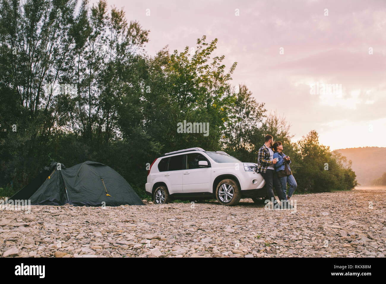 Matura in piedi che guarda su sunrise e bere il tè. car camping. concetto di stile di vita Foto Stock