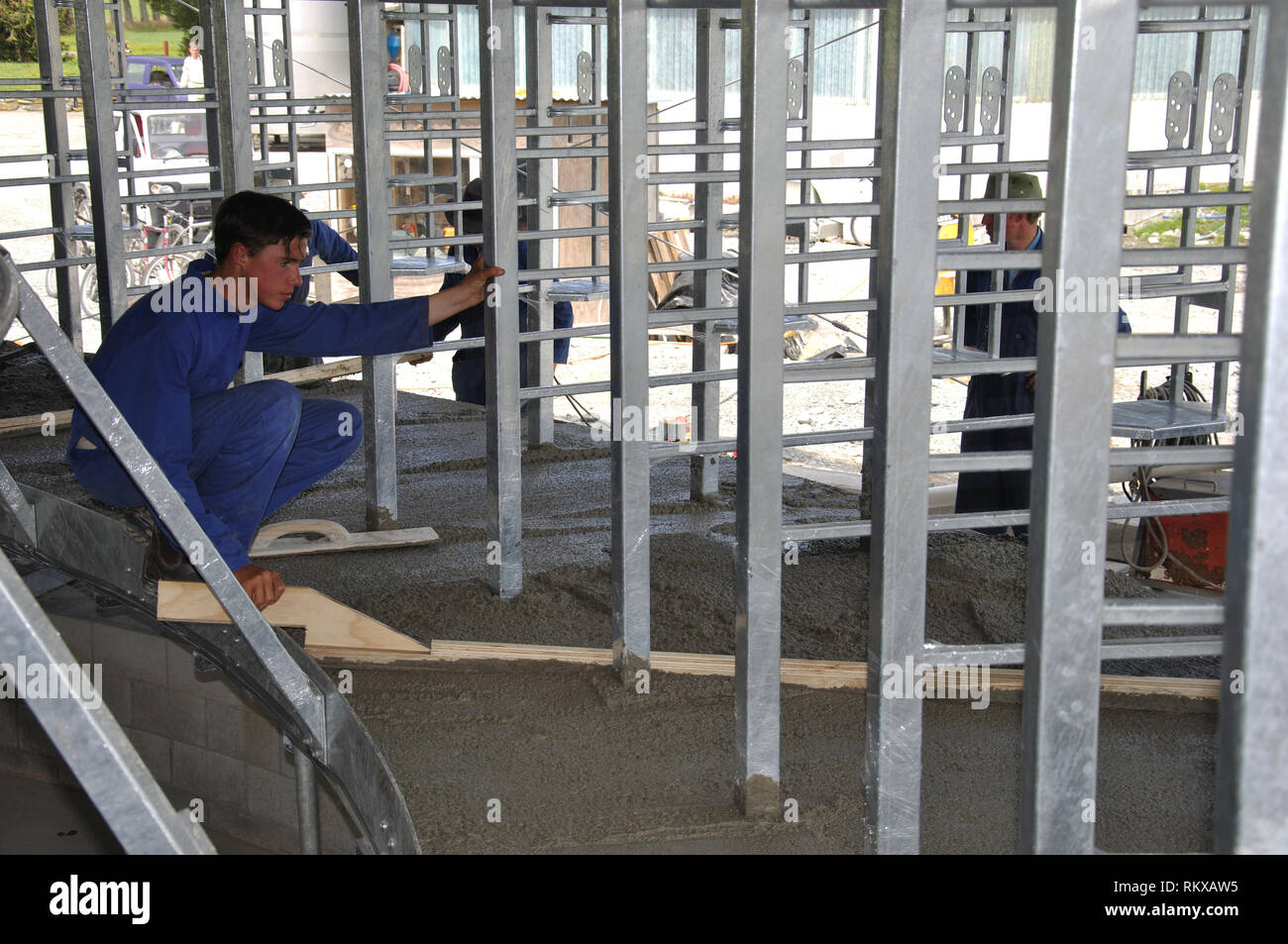 Costruttori di massetto appena fuori la colata di calcestruzzo piattaforma in un caseificio rotante Foto Stock