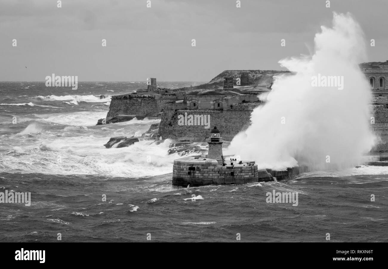 Ricasoli Oriente frangiflutti e faro resistere alle materie del mare e dalle onde alte. Fort Ricasoli, Kalkara, Malta, l'Europa. Foto Stock