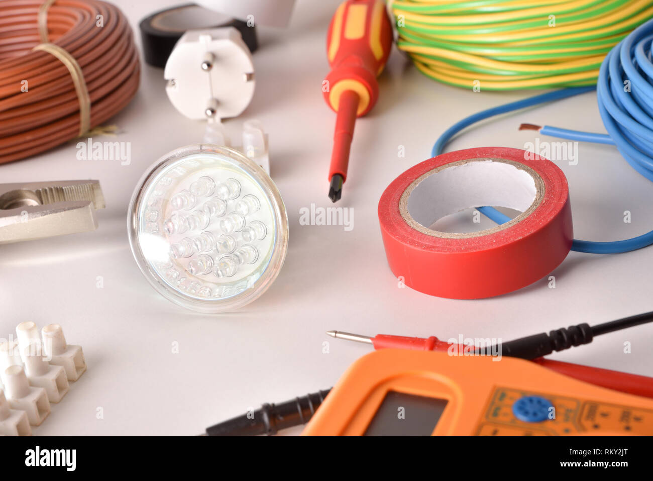Strumenti e materiale elettrico su un tavolo bianco vista generale composizione orizzontale. Vista in elevazione. Foto Stock