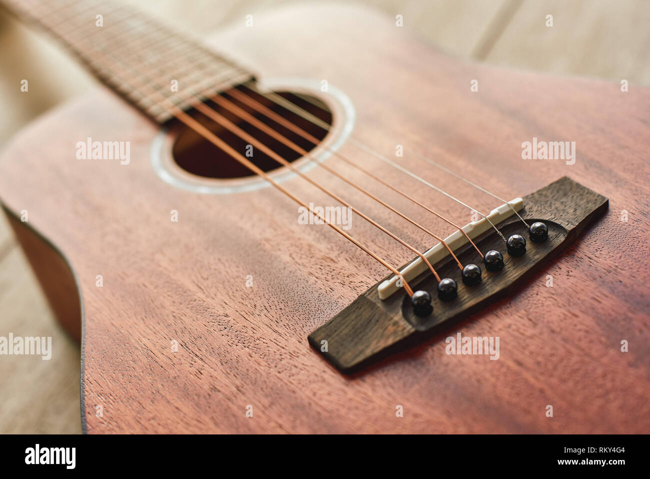 Romantica musica per chitarra...vicino la foto del brown chitarra acustica sdraiato sul pavimento in legno. Il concetto di musica. Strumenti musicali Foto Stock