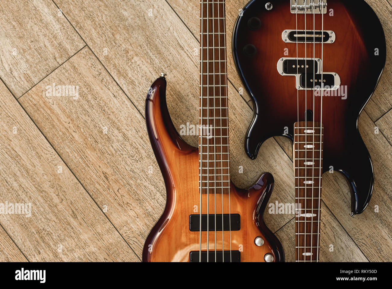 Armonia chitarre. Vista superiore della chitarre elettriche che giace vicino a ogni altra contro del pavimento in legno. Il concetto di musica. Strumenti musicali Foto Stock