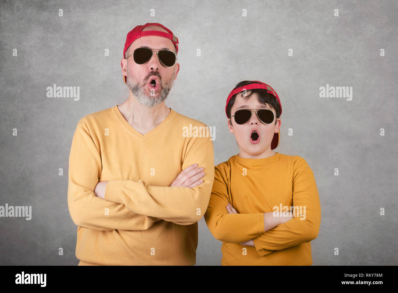 La festa del papà,padre e figlio con occhiali da sole e cappello su sfondo  grigio Foto stock - Alamy