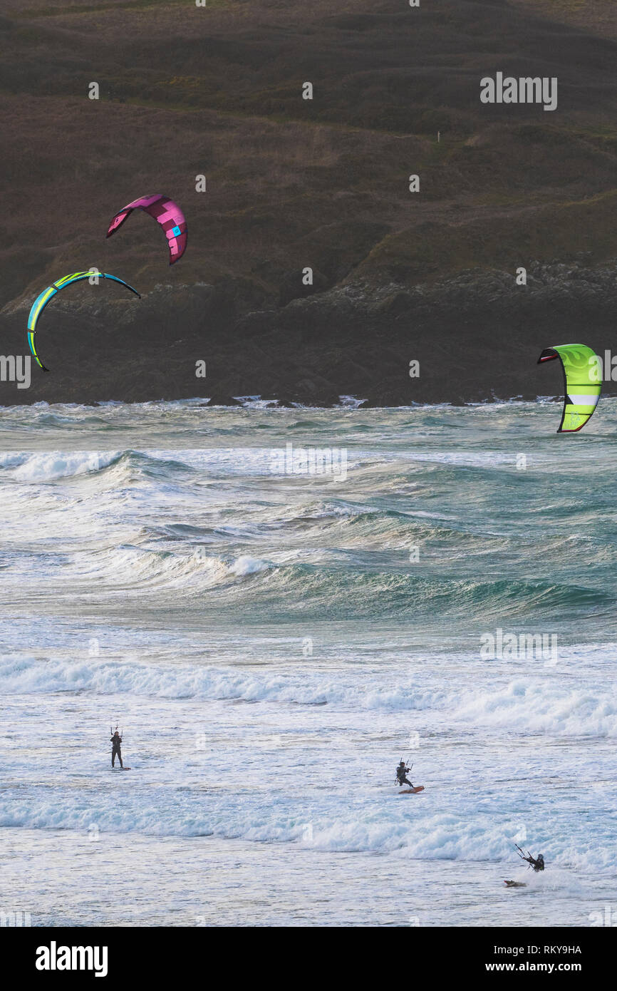 Kiteboarders kitesurf nel mare agitato a Crantock Beach in Newquay in Cornovaglia. Foto Stock