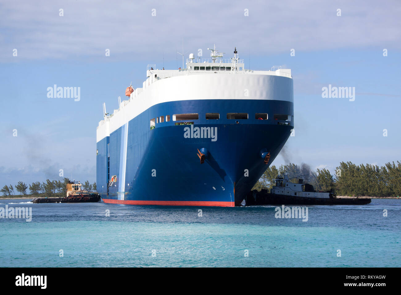 Due rimorchiatori spingendo gigantesca petroliera contribuendo alla manovra in porto di Nassau (Bahamas). Foto Stock